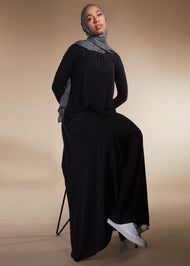 Black colour. Cut in 100% cotton jersey with a fitted bodice & voluminous drop. Styling details include a round neckline with subtle pleats. Features button fastenings on the back & sleeve cuffs.
