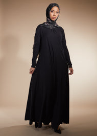 Black colour. Cut in 100% cotton jersey with a fitted bodice & voluminous drop. Styling details include a round neckline with subtle pleats. Features button fastenings on the back & sleeve cuffs.