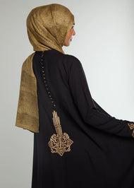 This simple yet elegant abaya features embroidery on the back and cuffs. Inspired by Islamic Art of Calligraphy. 'Celi' Is the name of a pen used for large forms of calligraphy. Black.