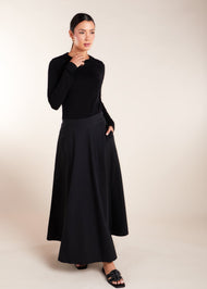 Constructed with premium quality natural cotton, this expertly crafted skirt boasts a half moon cut and a pristine high waistband. The discreet size zipper and button opening add a touch of functionality to this versatile piece. Classic black colour. 