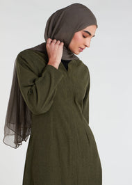Green cotton kimono featuring convenient high slits for effortless movement, buttons so you can wear open or closed, functional pockets, understated pleats, and a stunning green hue.