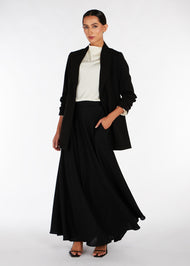 This classic must-have skirt is designed for all occasions, with a soft satin feel and subtle sheen that adds a touch of elegance and versatility to any outfit. Its flared design makes it a timeless choice. Skirt is long and black. 