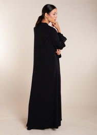 This elegant Two Piece Open Abaya set includes a Full Sleeve matching inner dress. Perfect for everyday wear, it can also be dressed up with accessories for an evening look. The open abaya can be worn as a maxi on its own or paired with the inner dress for a stylish ensemble. In black.
