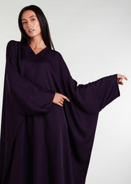 Our V Neck Kaftan in an intense aubergine hue features a front rise and cascading sides, creating a breezy and flowy aesthetic. This versatile piece is ideal for any summer occasion and paired with statement jewelry, it will elevate your overall look. 